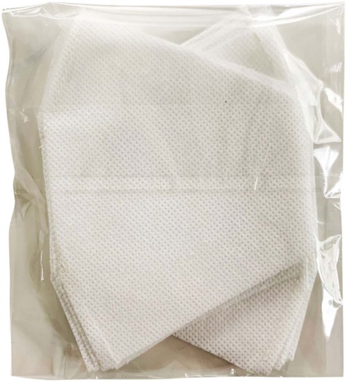 En hvit ansiktsmaske i en gjennomsiktig plastpose, pent brettet, med små prikker på maskens overflate.