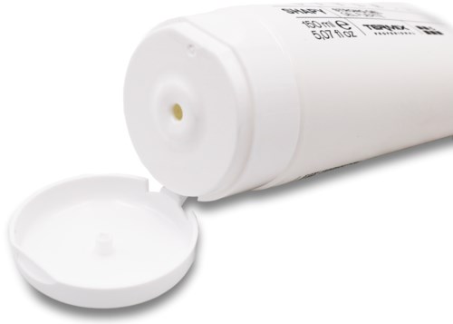En vit tub med ett lock, troligen ett medicin- eller krämbörs, ligger på en vit yta.