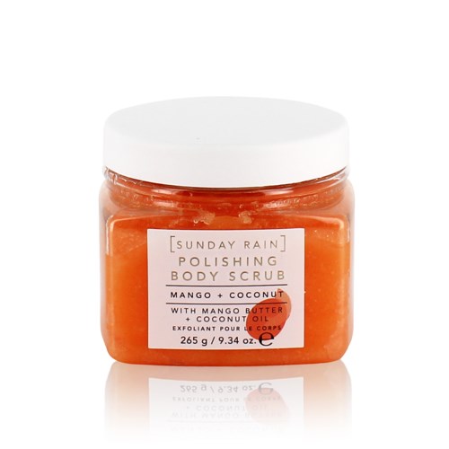 Et glass med kroppsskrubb i oransje farge, hvit lokk og etikett som viser mango og kokos ingredienser.