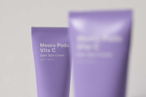 Två lila tuber med hudvårdscreme, en märkta 'Meoru Podo Vita C Dark Spot Cream'.