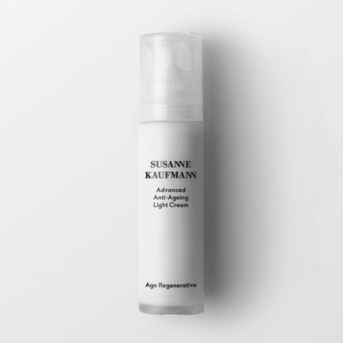 En hvit flaske merket Susanne Kaufmann Advanced Anti-Ageing Light Cream står oppreist mot en enkel bakgrunn.