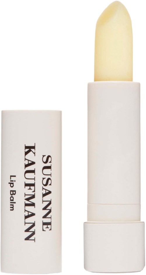 En vit läppstiftsrör med en gulaktig balsam inuti, märkt 'Susanne KAUFMANN Lip Balm'.