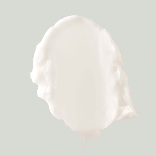 En klick vit grädde eller yoghurt med en slät, rund form på en ljus bakgrund.