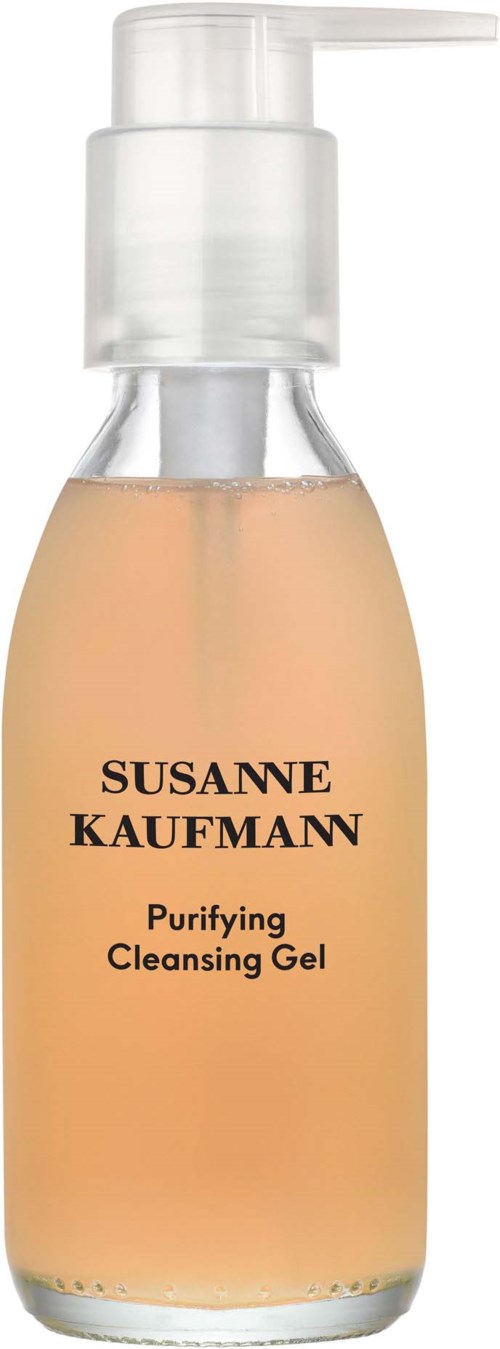En klar flaska med pump, märkt Susanne Kaufmann Purifying Cleansing Gel. Ljust orange gel i.