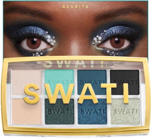 Bright eyes with glittery blue eyeshadow and white decorative dots, above an colorful eyeshadow palette.