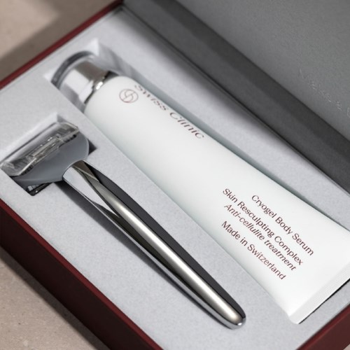 Ett hudvårdsset med en vit flaska märkt 'Cryogel Body Serum' och ett metallverktyg i en ask.