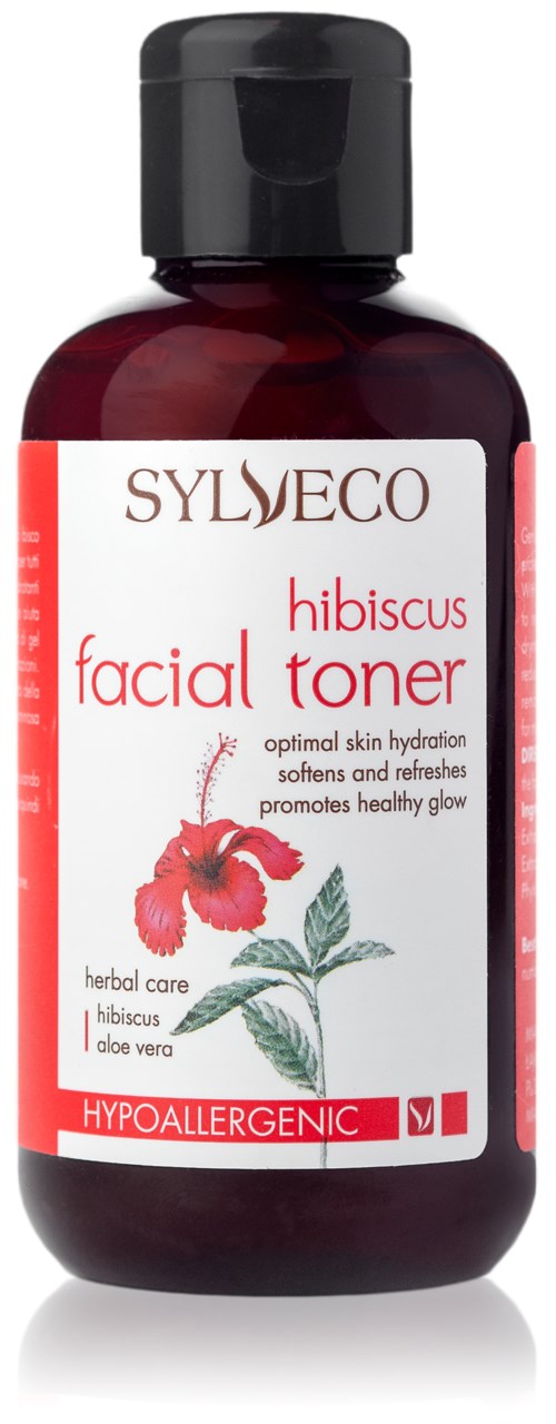 A bottle of hibiscus facial toner with a red label, a black cap, and a drawing of hibiscus flowers and leaves.