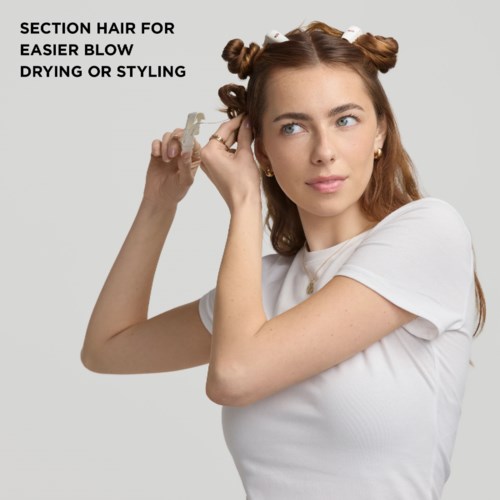 Kvinna med stylat hår som delar upp för enklare blow-drying eller styling.