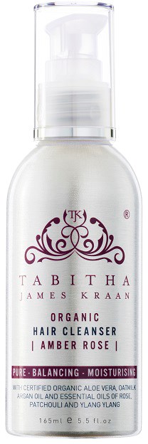 Een witte fles met pomp, gelabeld 'Labitha Organic Hair Cleanser' voor krullend haar, met een decoratief logo en roze accenten.