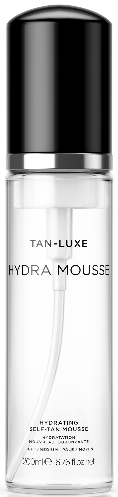 En tydlig flaska med svart lock, märkt 'TAN-LUXE Hydra Mousse,' med vitt flytande innehåll, används för solning.