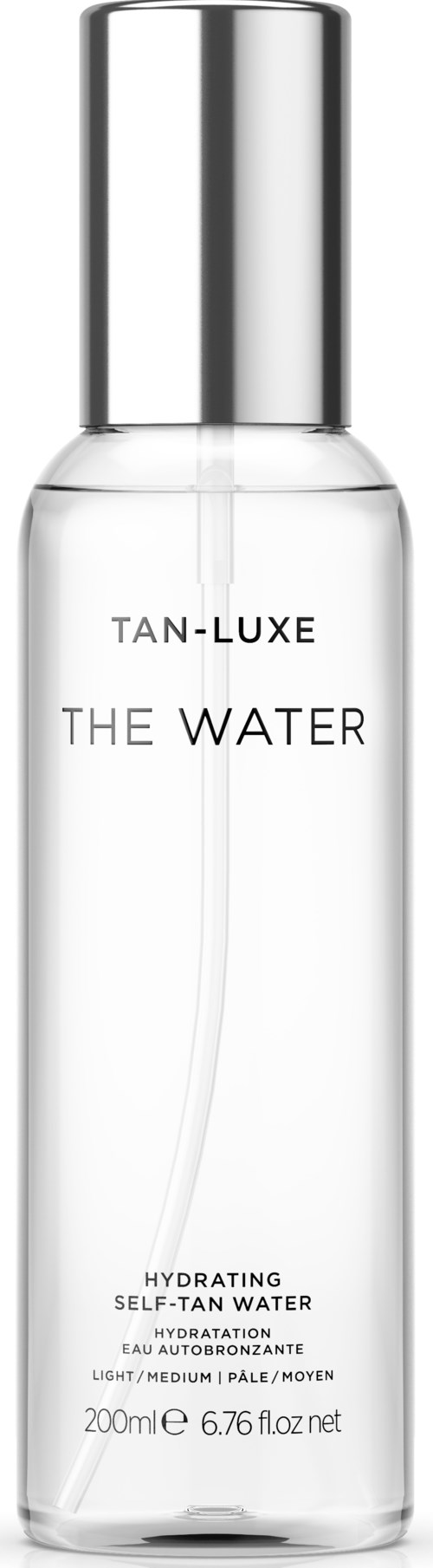 En klar, lang flaske med sølvhette merket "The Water" av Tan-Luxe, for hudfukting.