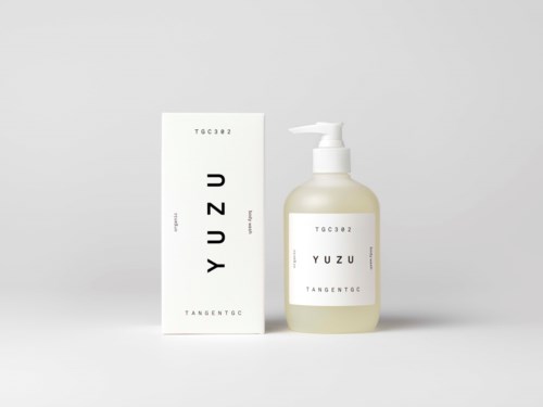 A white bottle with a pump next to a matching box, labeled with "YUZU" and minimalist text design.
