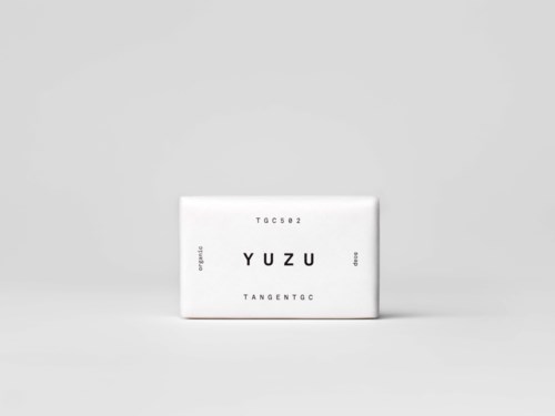 En vanlig vit ask med svart text som visar namnet YUZU och några koder på en grå bakgrund.