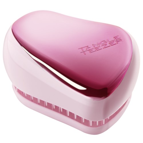 A pink heart-shaped device with the words "TANGLE TEEZER" on the top, used for hair brushing.