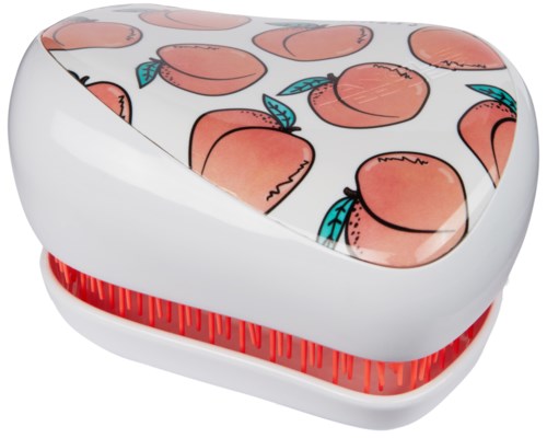 A white, heart-shaped box with peaches and blue leaves on the top. The box has a red striped bottom edge.