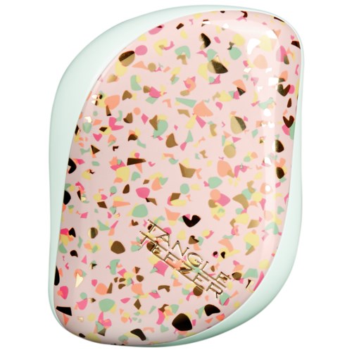 A compact makeup mirror with a pink, multi-colored confetti pattern. It has the word "TEENAGE" on it.