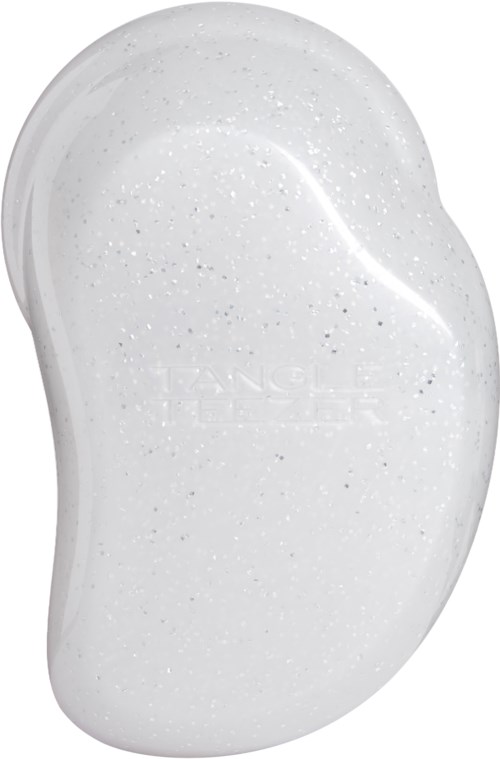 White soap with small dark specks, shaped like a bean or kidney. Small brand imprint visible in the center.