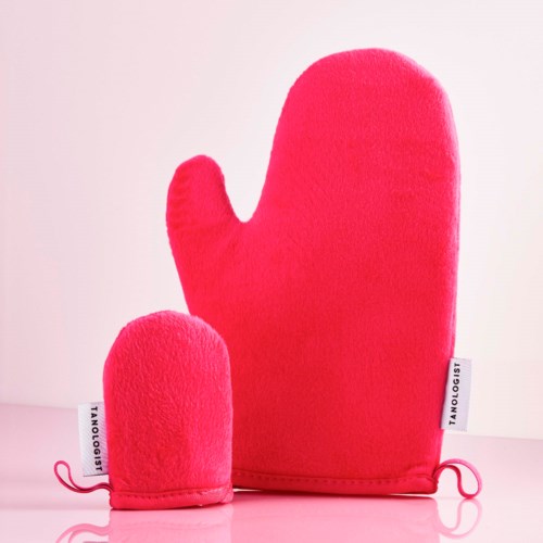 Zwei leuchtend pinke Ofenhandschuhe, eins groß und eins klein, liegen auf einer rosa Oberfläche. Sie sind weich und flauschig.