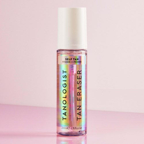 Holografistische Flasche für Selbstbräunungsentferner und Primer mit weißem Deckel, vor rosa Hintergrund.