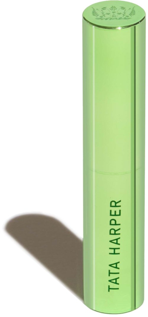 En lång, grön, cylindrical föremål med texten "TATA HARPER" skrivet vertikalt, kastar skugga.
