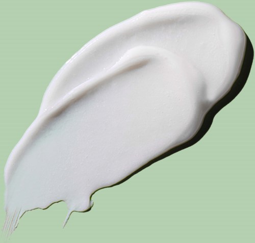 A dollop of white cream spread on a light green background.