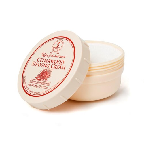 Ympyrän muotoinen rasia Cedarwood-parranajovoiteelle, kannen päällä on punainen ja valkoinen etiketti. Kansi on osittain auki.