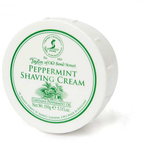 En rund behållare med pepparmints skäggkräm från Taylor of Old Bond Street, med grönt skrivande och en pepparmintplanta.