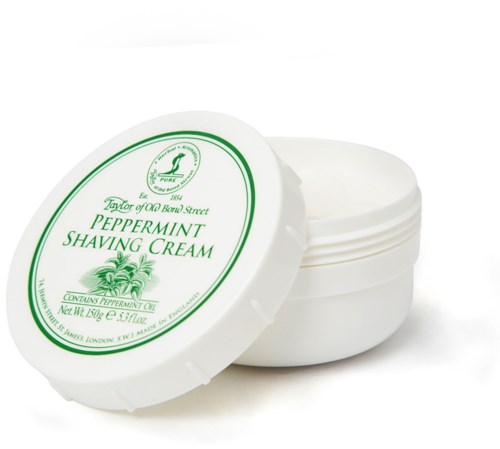 En vit behållare med lock märkt 'Peppermint Shaving Cream' i grönt, med en pepparmintplantation.