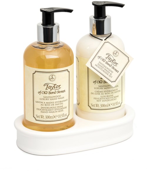 Två flaskor handtvätt eller lotion på en vit bricka, en klar med gul vätska, den andra vit, märkt Taylors.