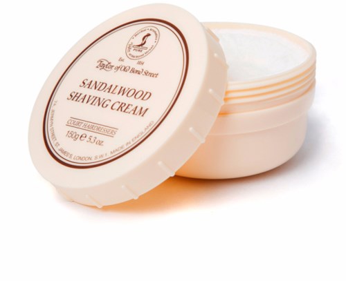  ronde container met crème, gemarkeerd als Sandelhout scheerschuim, gedeeltelijk open, toont witte crème erin.