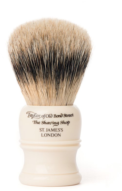 En rakborste med vit handtag märkt 'Taylor of Old Bond Street, The Shaving Shop, St. James, London' och täta borst.