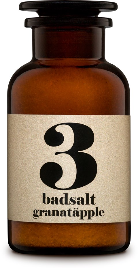 En brun flaska med en beige etikett som visar siffran 3 och orden 'badsalt granatäpple'.
