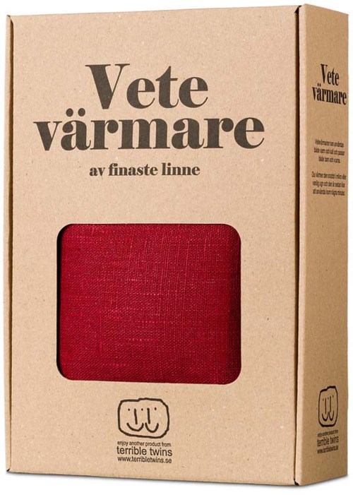 En papkasse med tekst på dansk og et vindue med et rødt stofplet. Kassen er til et uldtæppe.