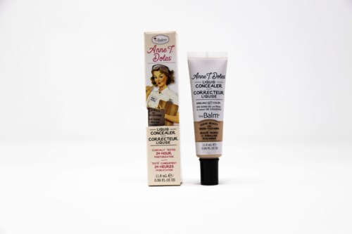 Læbeconcealer rør og boks med billede af en kvinde med brunt hår. Tekst viser, det er fra The Balm.