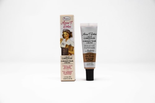 En lille tube concealer med vintage-udseende emballage og en matchende æske, mærket 'Annette Dotes' og 'Liquid Concealer'.