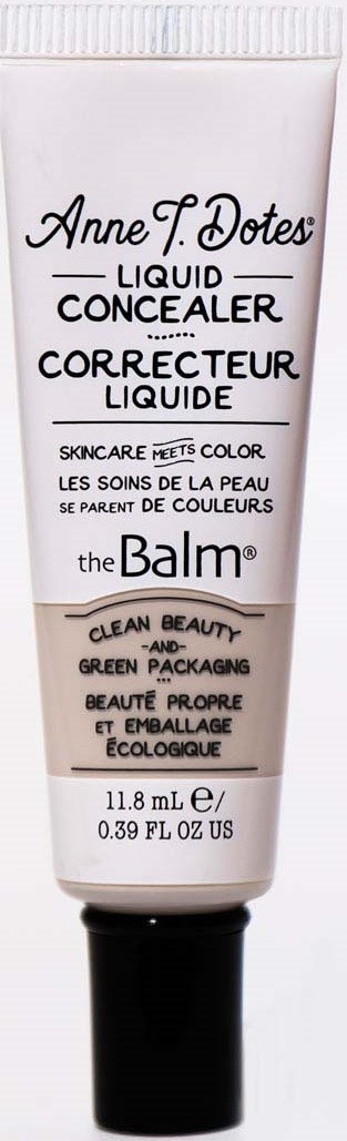 En hvid tube med The Balm flydende conceal, med sort låg, med produktnavn og beskrivelse i sort og pink tekst.