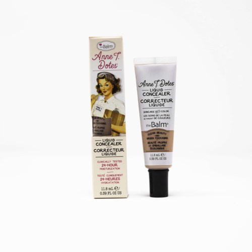 En tube af Liquid Concealer fra the Balm, med emballage, der viser en vintagekvinde og tekstdetaljer.