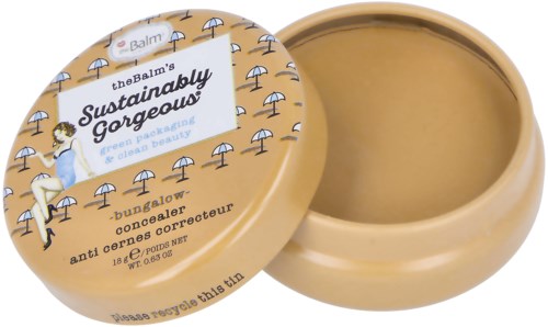 En burk av The Balm's anti-cernes med ett beige lock, dekorerad med små paraplyer, och text om hållbarhet och skönhet.