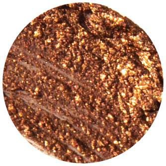 Et nærbillede af en brun tekstureret overflade med guldglitter, sandsynligvis et makeup- eller kosmetikprodukt. Den har skinnende, glitrende partikler.