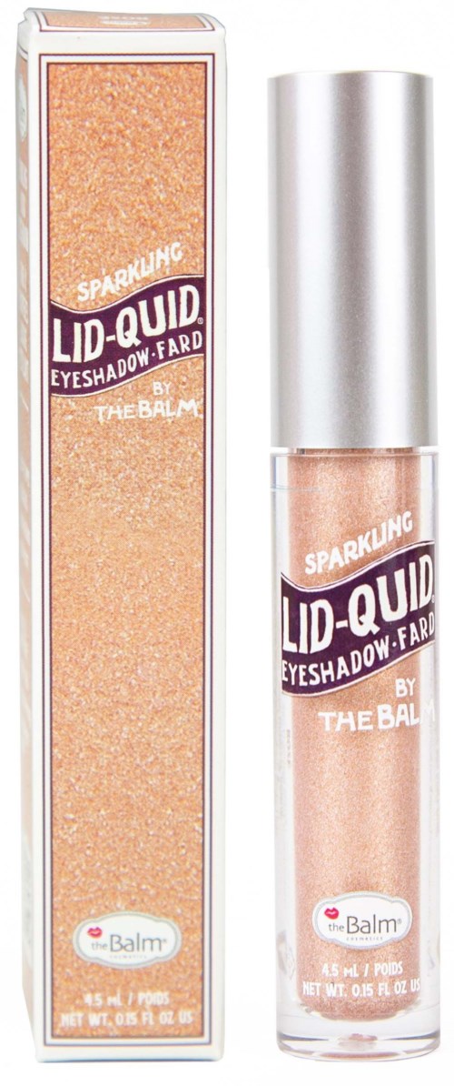 En glitrende øjenskygge i klar flaske med sølvhætte, og dens æske. Etiketten siger "Lid-Quid" by The Balm.