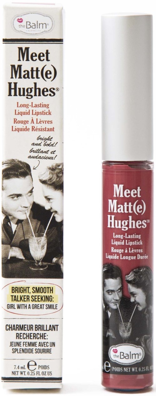 Ett långtidsverkande rosa läppstift med vit kork, märkt Meet Matt(e) Hughes av theBalm, bredvid sin förpackning.