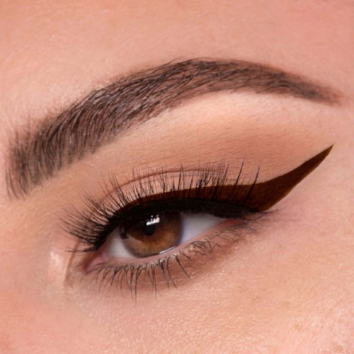 Nærbillede af et øje med detaljeret makeup, herunder brun øjenskygge, eyeliner og lange øjenvipper.