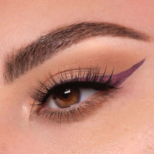 Nærbillede af et kvindes øje med makeup, herunder lyserød eyeliner og lange øjenvipper.