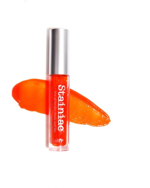 Læbepomade med orange gel i klar tube, med en orange stribe bagved.