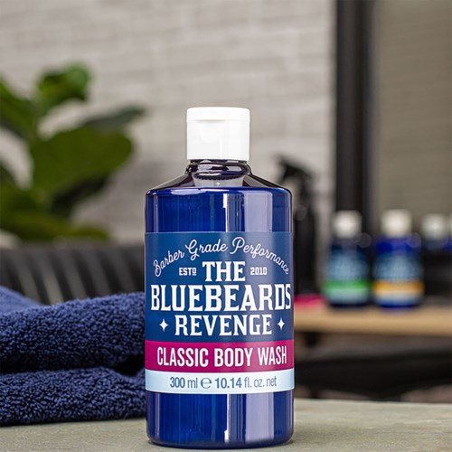 A blue bottle labeled "Classic Body Wash" from The Bluebeards Revenge, 300ml, on a counter.