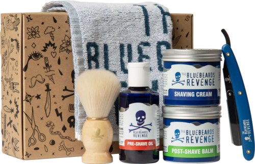 Grooming set with shaving cream, pre-shave oil, post-shave balm, brush, towel, and safety razor in a box.