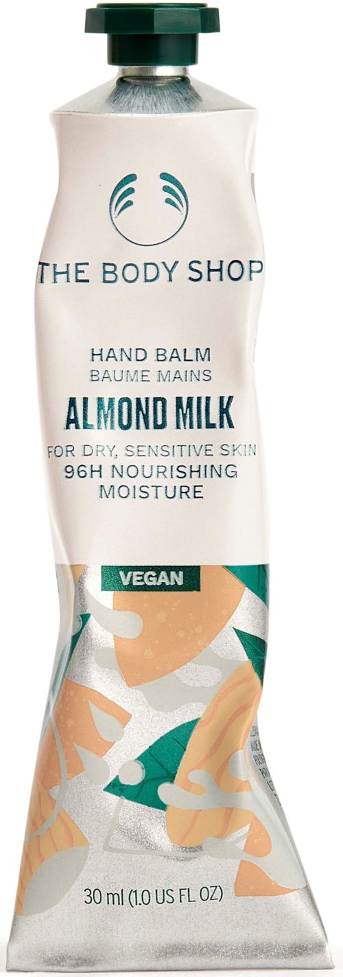Eine weiße Tube Handbalsam mit grünem Deckel, gekennzeichnet 'The Body Shop Almond Milk Vegan Hand Balm' für empfindliche Haut.
