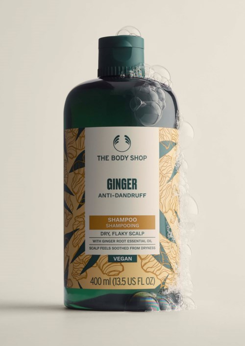 Vihreä pullo inkivääriä ehkäisevää shampoota, beige etiketti ja vihreä korkki.