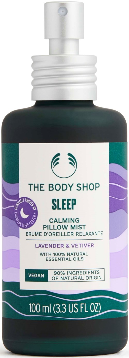 En svart sprayflaska med Sleep Calming Pillow Mist från The Body Shop, med lila, grönt och vitt etikett.