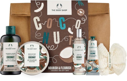 A body care gift set with coconut-scented products and a brown paper bag.